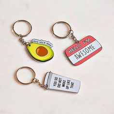 three keychains with an avocado, ketchup, and some other items on them