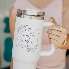 a woman holding a white coffee mug in her hand