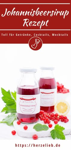 two bottles of raspberry syrup sitting on top of a white table with green leaves