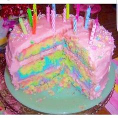 there is a cake that has many candles on it and pink frosting with sprinkles