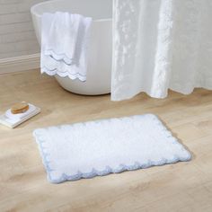 a white bath mat sitting on top of a wooden floor