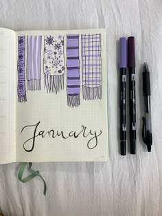 an open notebook with the word january written in cursive writing next to some pens