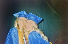 two women in graduation caps and gowns posing for a photo with their arms around each other