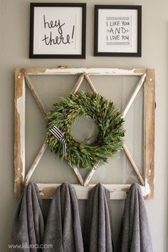 an image of a wreath and two framed pictures on the wall with words above it