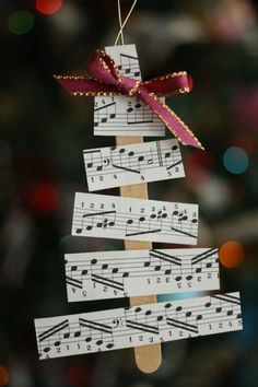 an ornament made out of sheet music is hanging on a christmas tree branch