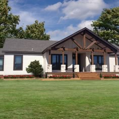 a white house sitting on top of a lush green field