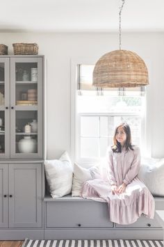 a woman sitting on top of a window sill