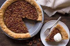 a pecan pie on a plate with a slice taken out and a fork next to it