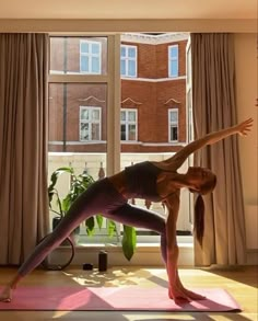 a woman doing yoga in front of a window