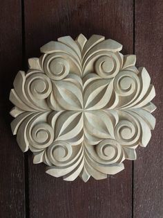 a wooden wall hanging on the side of a door with an intricately carved design