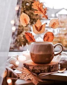 a coffee cup sitting on top of a table next to a window