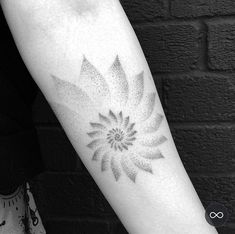 a black and white photo of a woman's arm with a flower tattoo on it