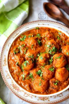 a bowl filled with meatballs covered in sauce and garnished with parsley