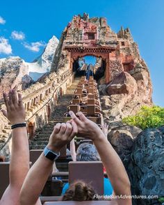 people are reaching up to the top of a mountain