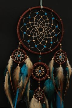 a dream catcher with feathers and beads hanging from it's side on a black background