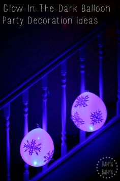 two snowflaked balls sitting on top of a banister in the dark