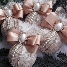 three ornaments with bows and pearls on them