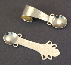 two spoons with metal handles on a table