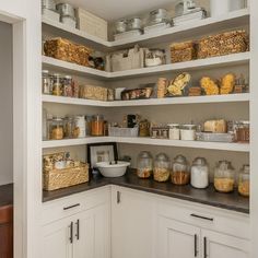 an organized pantry with lots of food in glass jars and containers on the shelves,