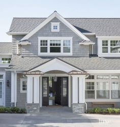 a large gray and white house with lots of windows