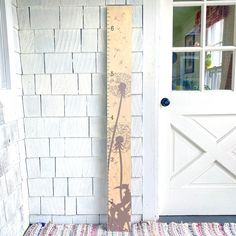 a tall wooden ruler sitting next to a white door