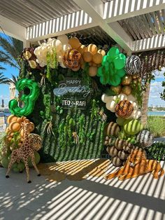 an outdoor display with balloons and jungle decorations