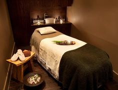 a massage room with candles and towels on the bed