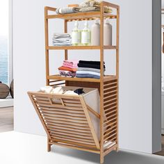 a wooden shelf filled with lots of towels and other bathroom items next to a window