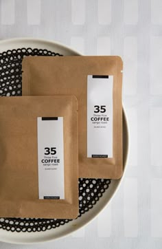 two bags of coffee sitting on top of a white plate