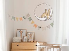 a baby's room with a crib, dresser and pictures on the wall