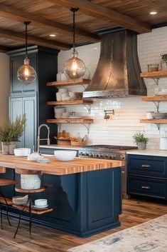 a large kitchen with blue cabinets and wooden shelves on the wall, along with hanging lights