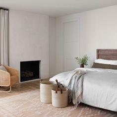 a bedroom with a bed, two baskets and a fire place in the middle of the room