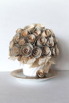 a bouquet of paper flowers sitting on top of a saucer