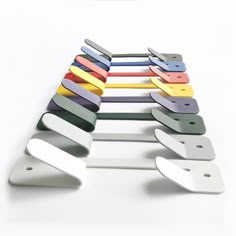 a bunch of different colored paper clips sitting on top of each other in front of a white background