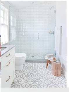 a bathroom with white and gray tiles on the floor