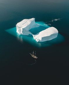 an iceberg floating in the ocean next to a boat