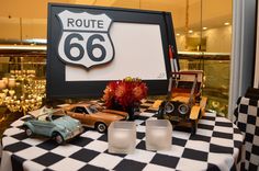 a table with cars and candles on it in front of a sign that says route 66