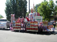 a parade float with red, white and blue decorations on it's back in the street