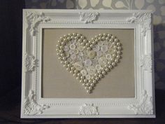 a heart made out of buttons in a frame