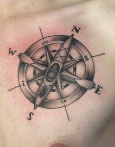 a man with a compass tattoo on his chest