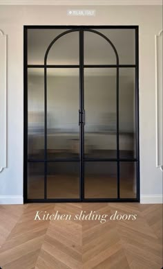 an open glass door with the words kitchen sliding doors on it in front of a wooden floor