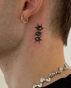 a man's neck with an eye tattoo on the back of his neck and behind his ear