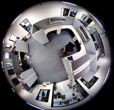 an aerial view of a room with multiple desks and computer screens on the walls