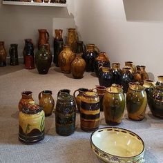 there are many vases and bowls on the floor