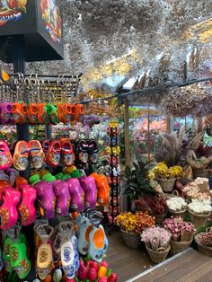 there are many items for sale in the store that is decorated with flowers and umbrellas