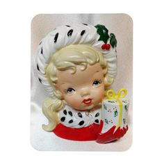 a ceramic figurine of a girl with a christmas present in her hand, on a white background