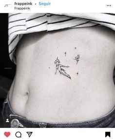 a woman's stomach with a small tattoo on the side of her body and stars