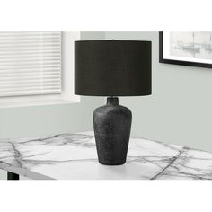 a black lamp sitting on top of a marble table