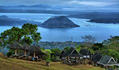 a group of huts sitting on top of a lush green hillside