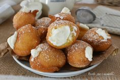 a white plate topped with donuts covered in icing and powdered sugar on top of a table